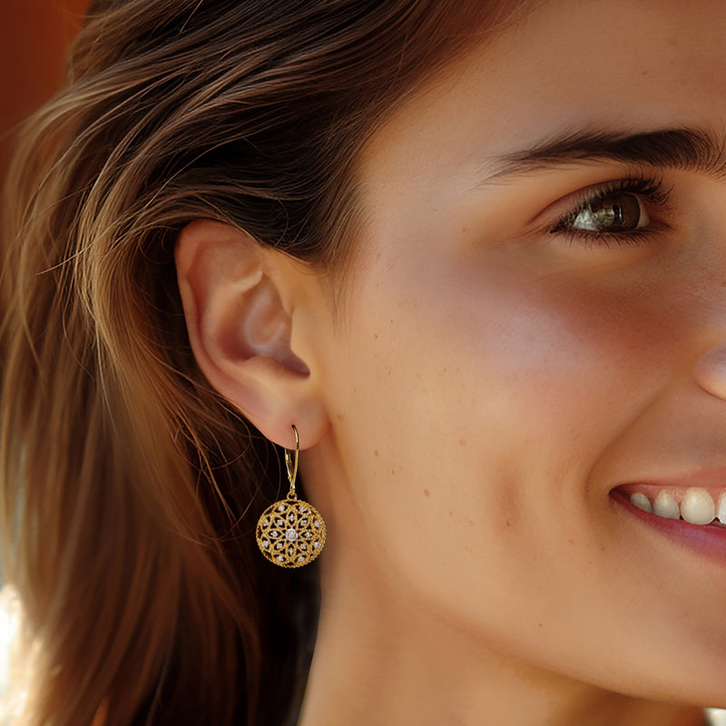 Gold round leverback drop earrings with openwork floral design and center gemstone