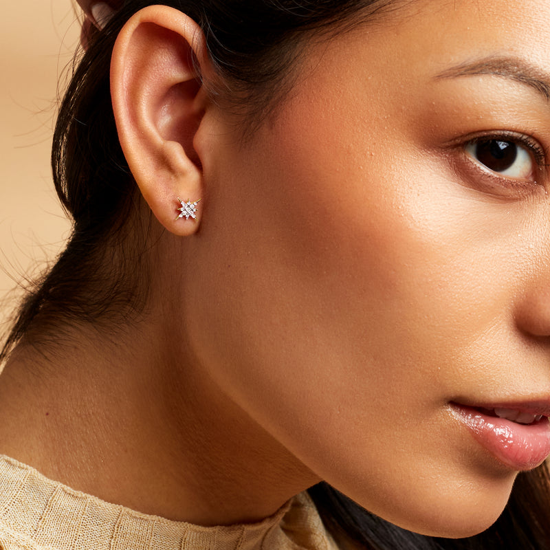 Diamond star stud earring on model’s ear with round-cut stones