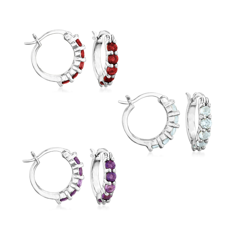 Sterling silver huggie hoop earrings set with red, blue, and purple gemstone rows