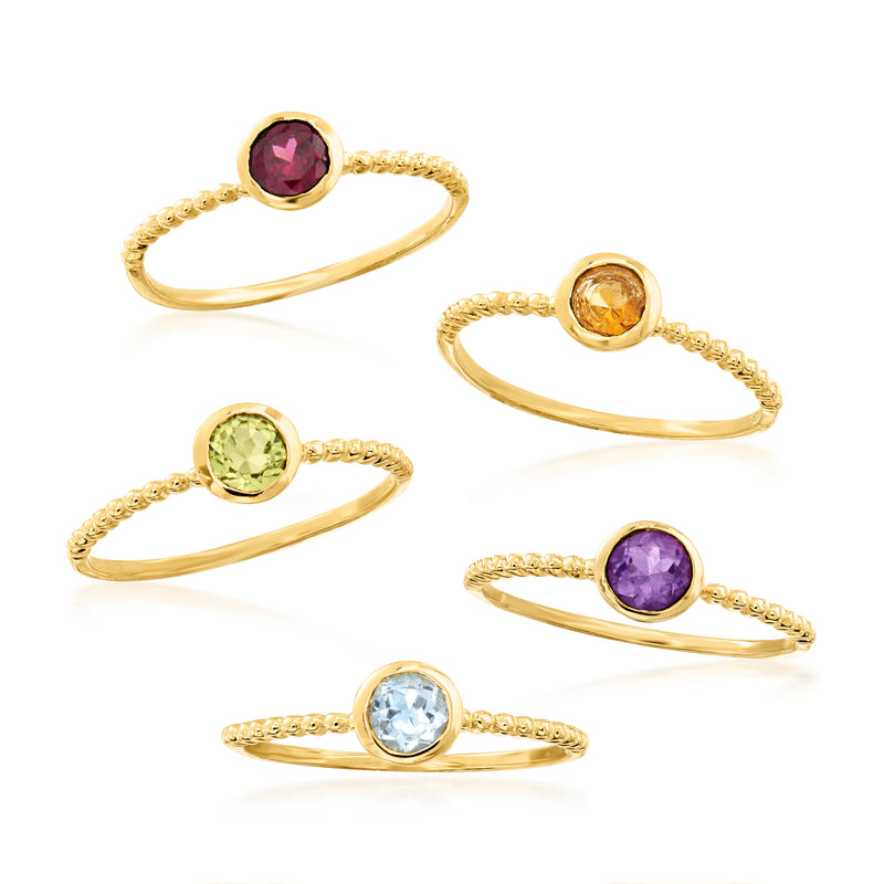 Five gold-tone rings with round gemstones: purple, orange, green, violet, blue