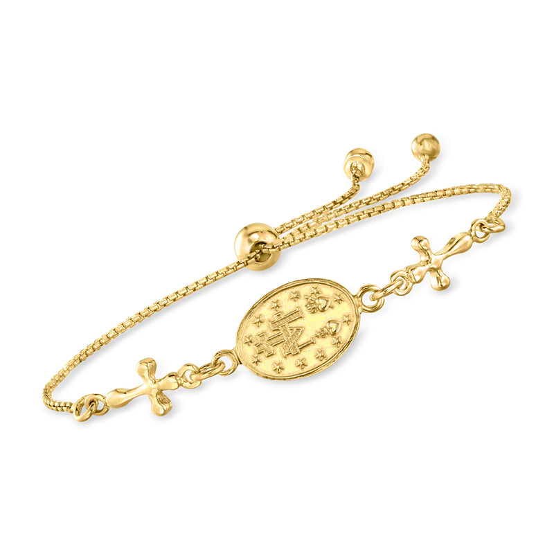 Gold-tone bolo bracelet with oval medal pendant and two cross charms