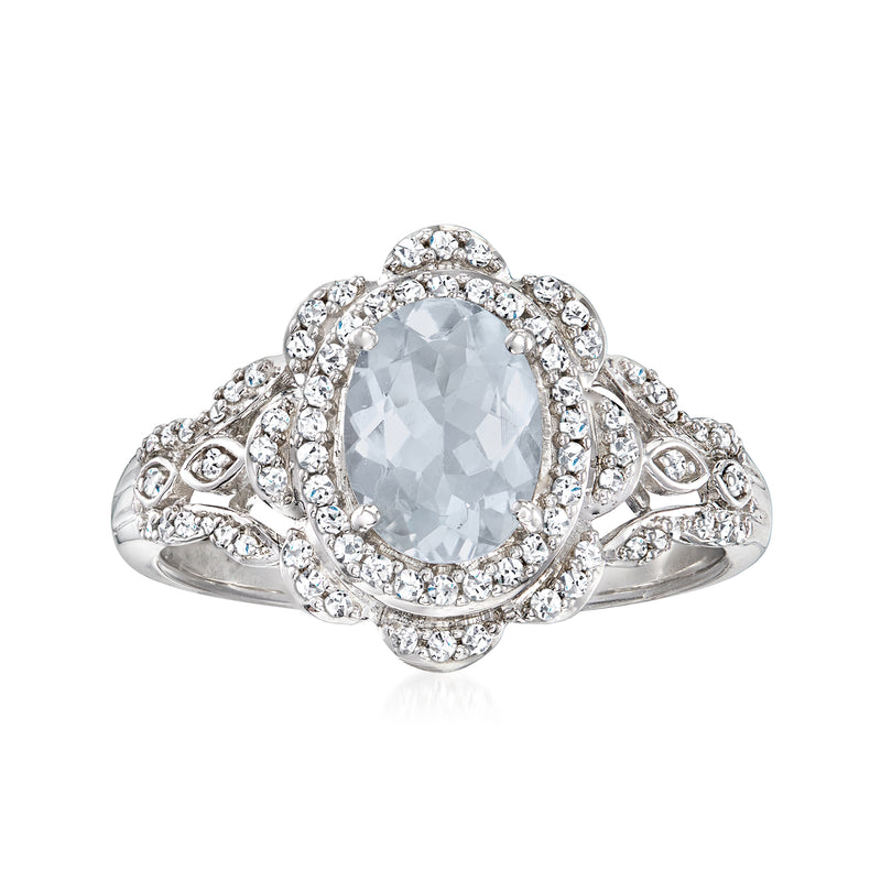 Sterling silver halo ring with oval aquamarine-colored center stone and diamond accents