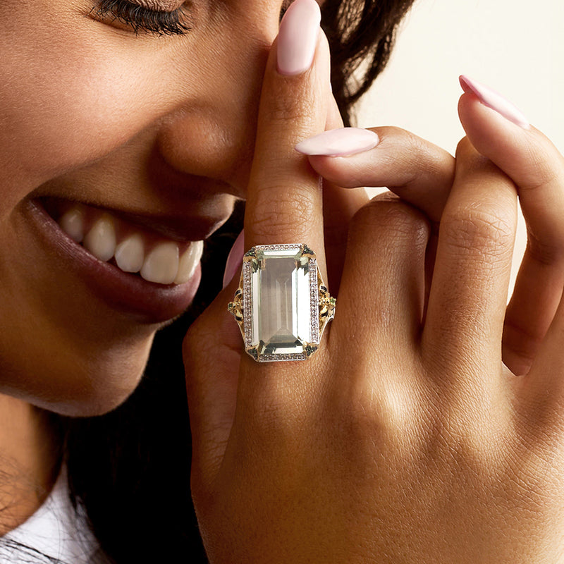 Prasiolite ring worn on finger: emerald-cut green center, white topaz frame, gold band