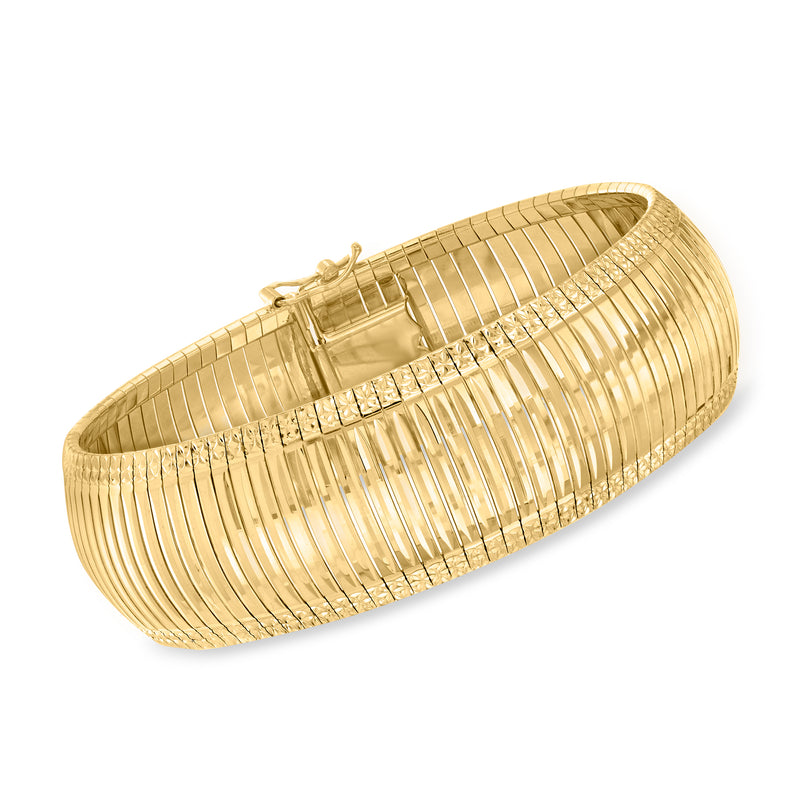 Wide gold-tone bracelet with textured and polished ridges, hinged closure