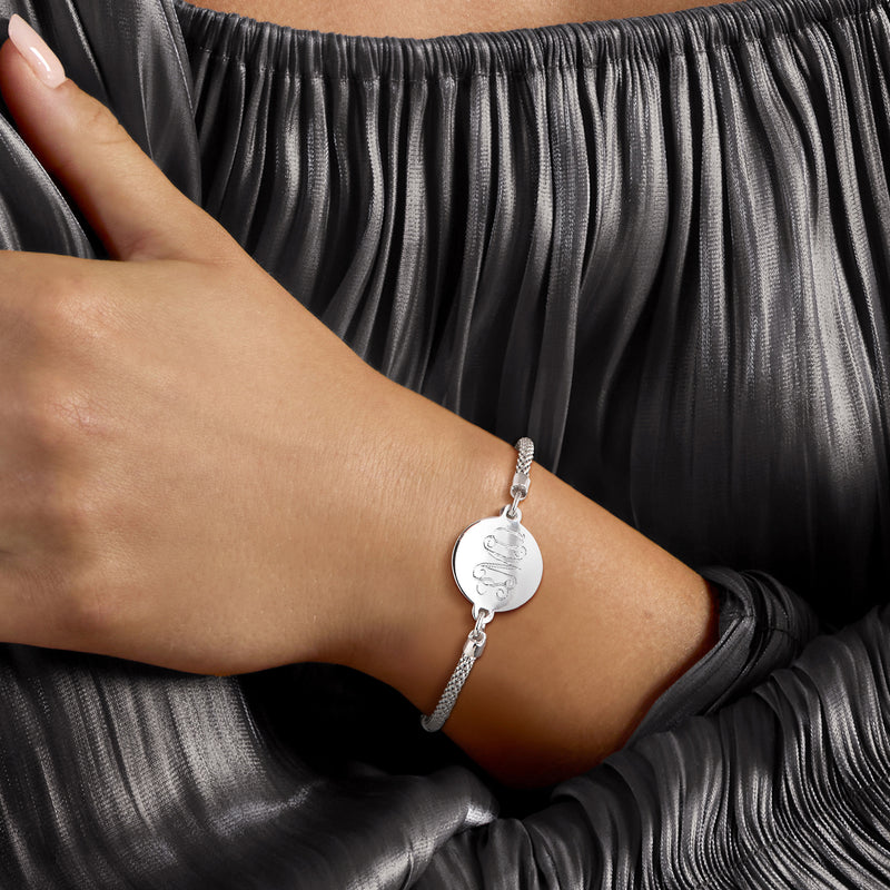 Sterling silver bolo bracelet worn on wrist with engraved heart disc charm