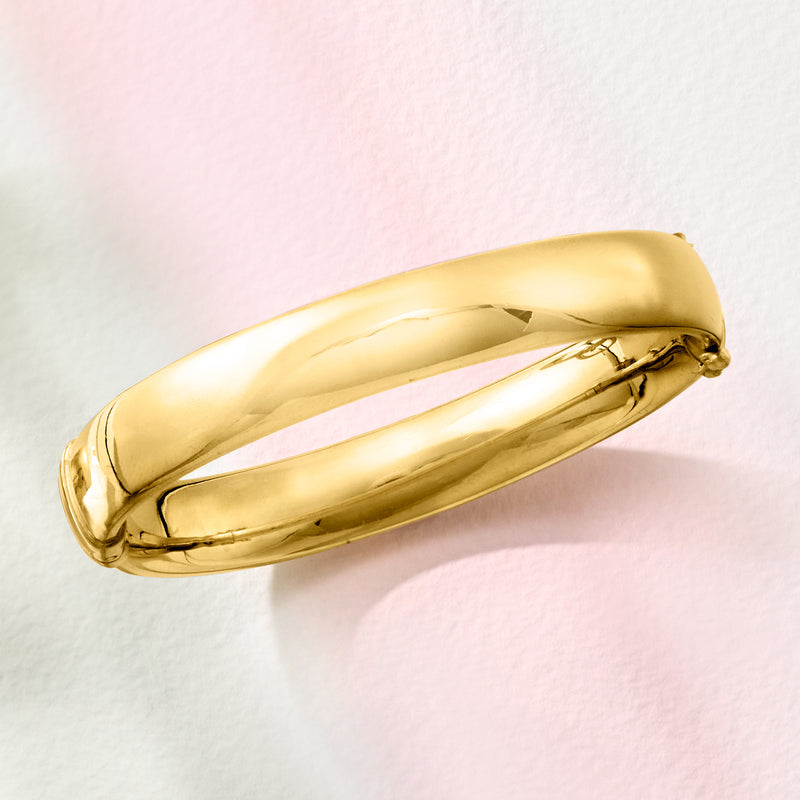 Gold-tone bangle bracelet, side view with clasp detail and smooth finish
