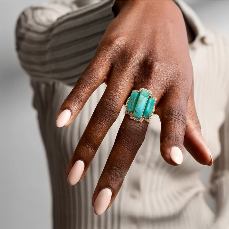 Turquoise square-cut gemstone ring on hand with gold-tone band and white stone border