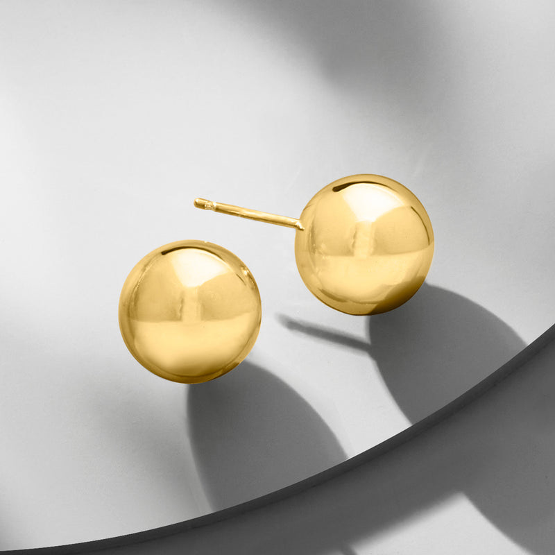 Gold ball stud earrings shown from the side, round discs with straight posts