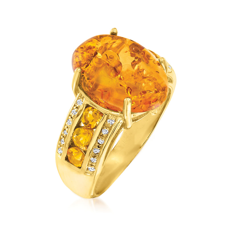 Gold over sterling ring featuring oval amber-colored center stone with faceted side stones