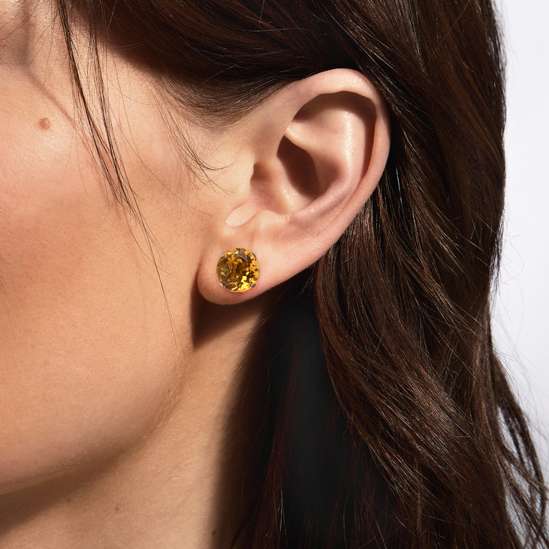 Round citrine stud earring in 14kt yellow gold, close-up on ear
