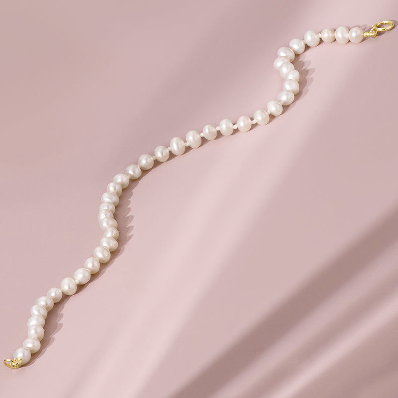 White pearl bracelet with gold clasp, single row design