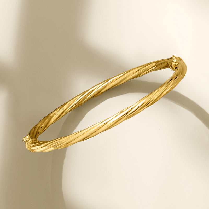 Twisted gold over sterling bangle bracelet, angled view with knot end caps