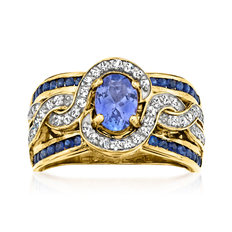 Gold-tone oval tanzanite ring with blue center stone, white zircons, and sapphire side accents