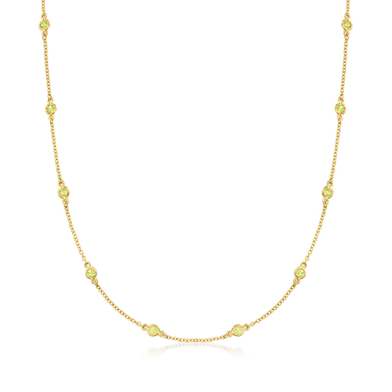 Gold peridot station necklace with bezel-set oval green gemstones on a fine chain