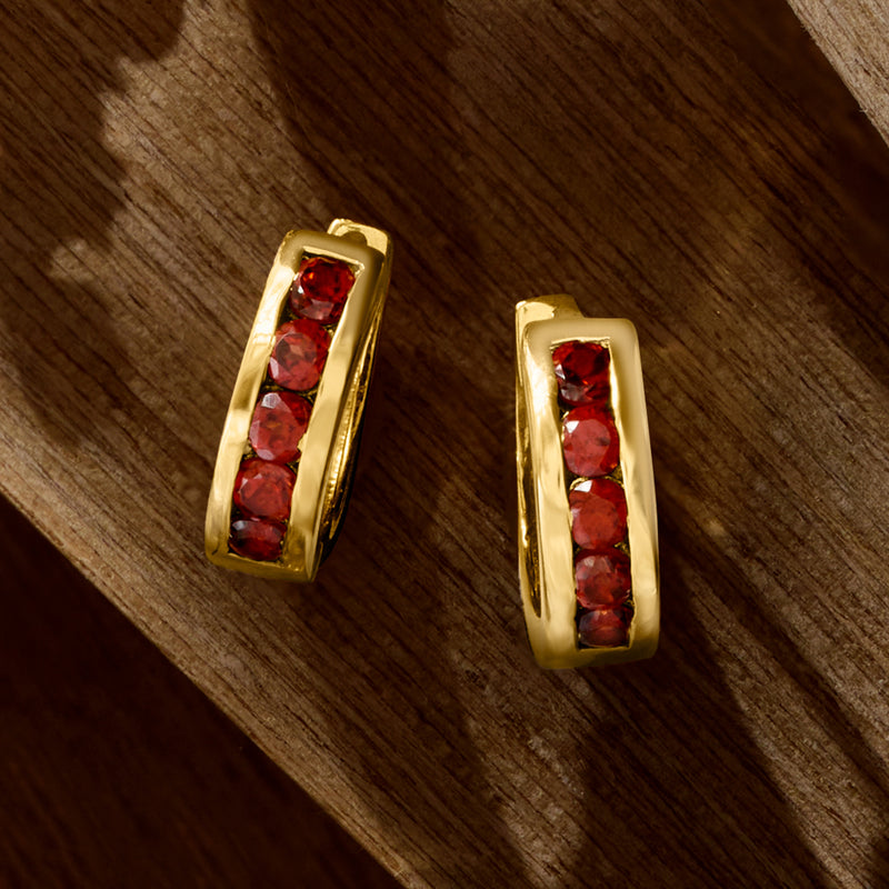 Gold huggie hoops with vertical row of red garnet stones, side view
