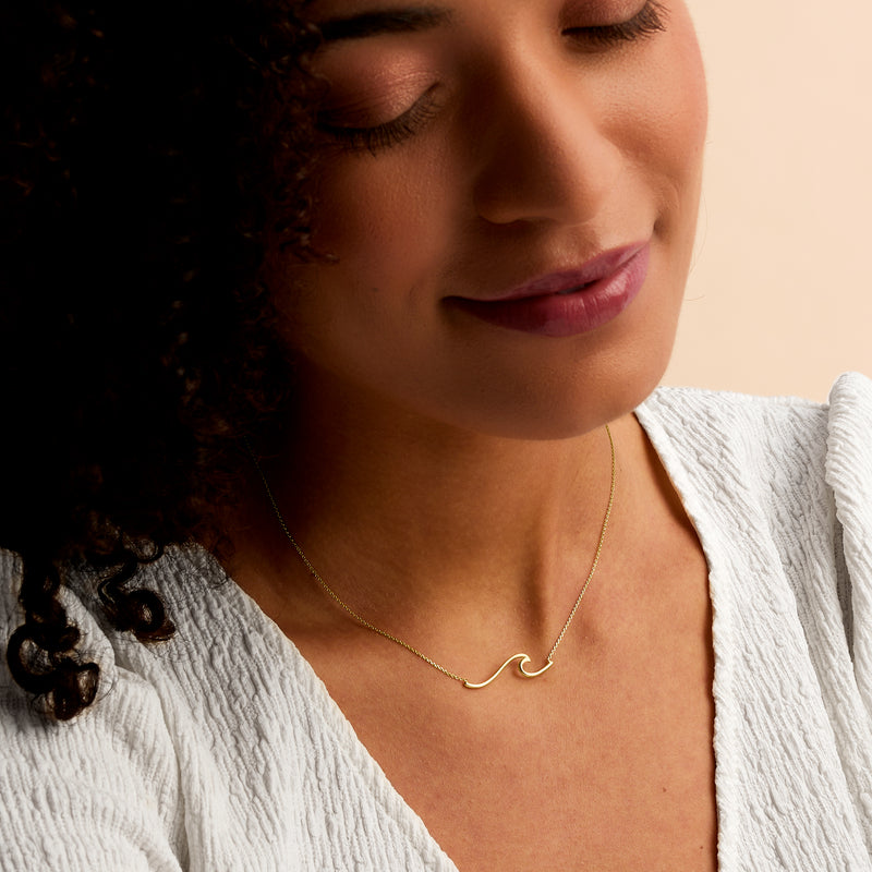 14kt yellow gold wave necklace with small curved wave pendant on thin chain