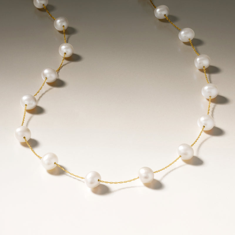 Pearl station necklace with 14kt yellow gold chain and white round pearls, close view