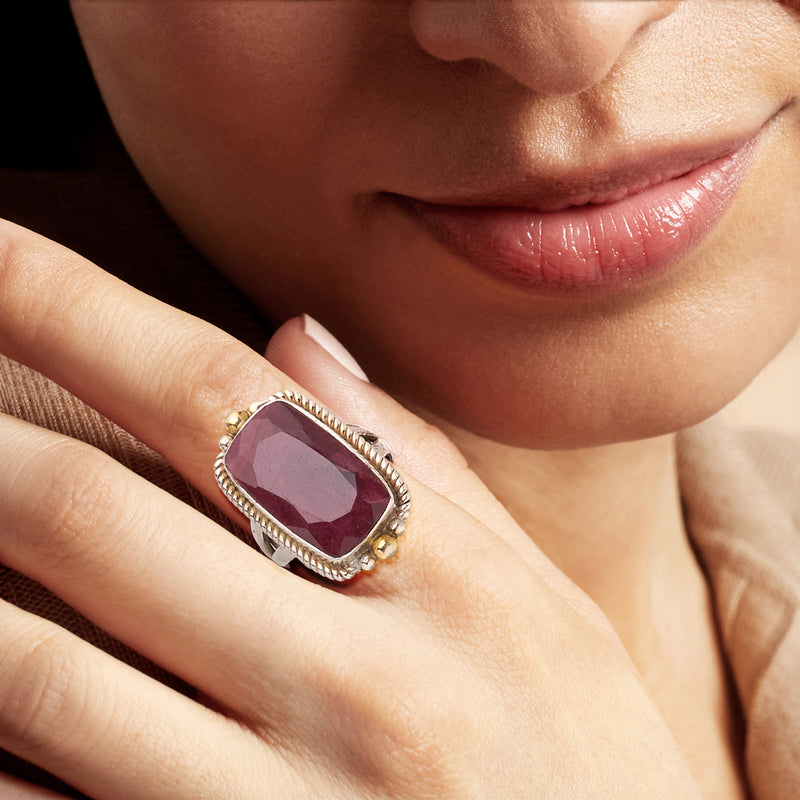 Ruby gemstone ring on finger with rope border and gold side accents, sterling silver
