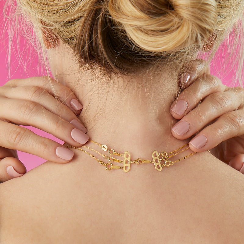 14kt yellow gold layering clasp with heart cutout plates on a layered necklace