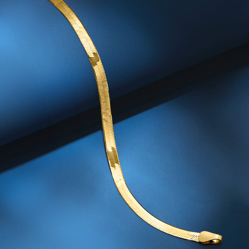 Yellow gold herringbone bracelet close-up with smooth end link and clasp