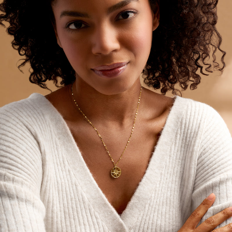 14k yellow gold compass pendant necklace worn on a fine chain