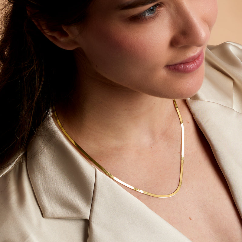 14kt yellow gold herringbone necklace worn, slim curved neckline