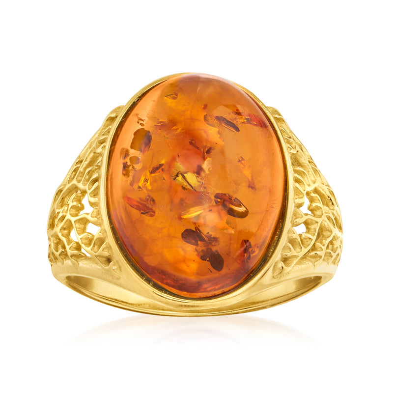 Oval amber cabochon ring with gold-tone filigree bezel and textured band