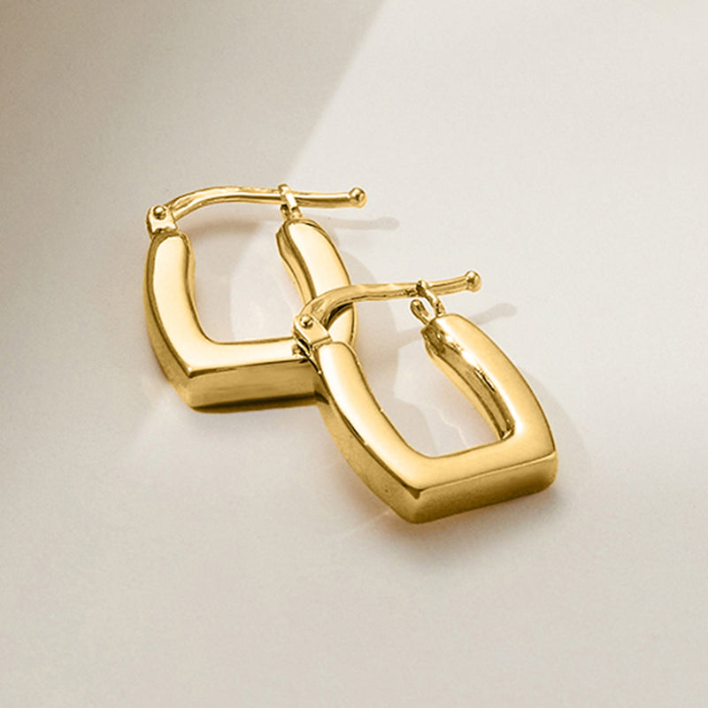 Angled view of square yellow gold hoop earrings with polished 14kt frame and posts