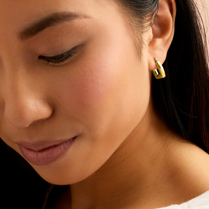 Square yellow gold hoop earrings on ear, polished 14kt style with post backs