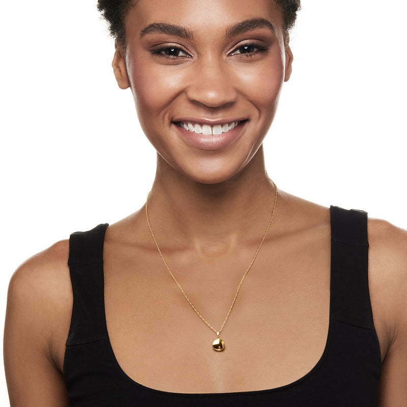 Yellow gold necklace with round concave disc pendant worn at collar length
