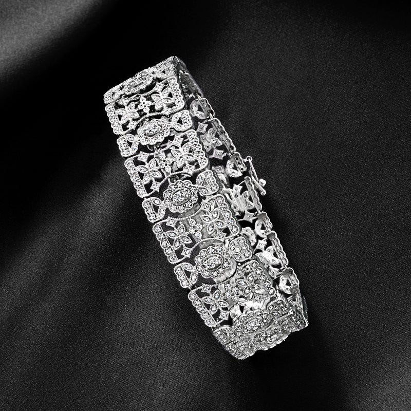 Sterling silver diamond floral bracelet with repeating oval and round stone motifs, side view