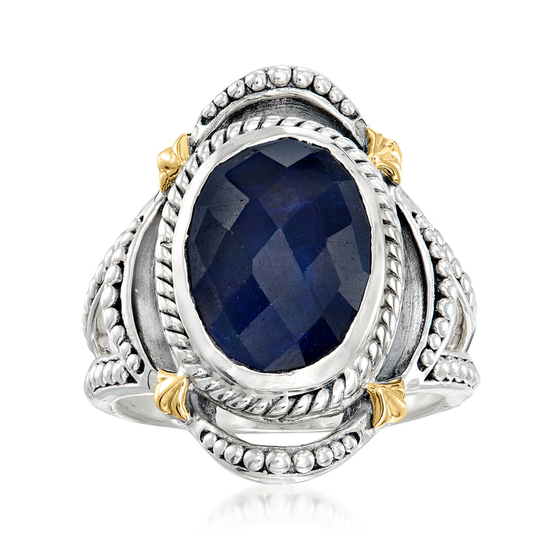 Oval sapphire ring with dark blue stone, sterling silver bezel and yellow gold accents
