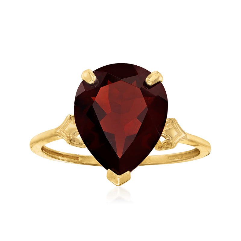 14kt yellow gold garnet ring with oval gemstone and fleur-de-lis style side engravings