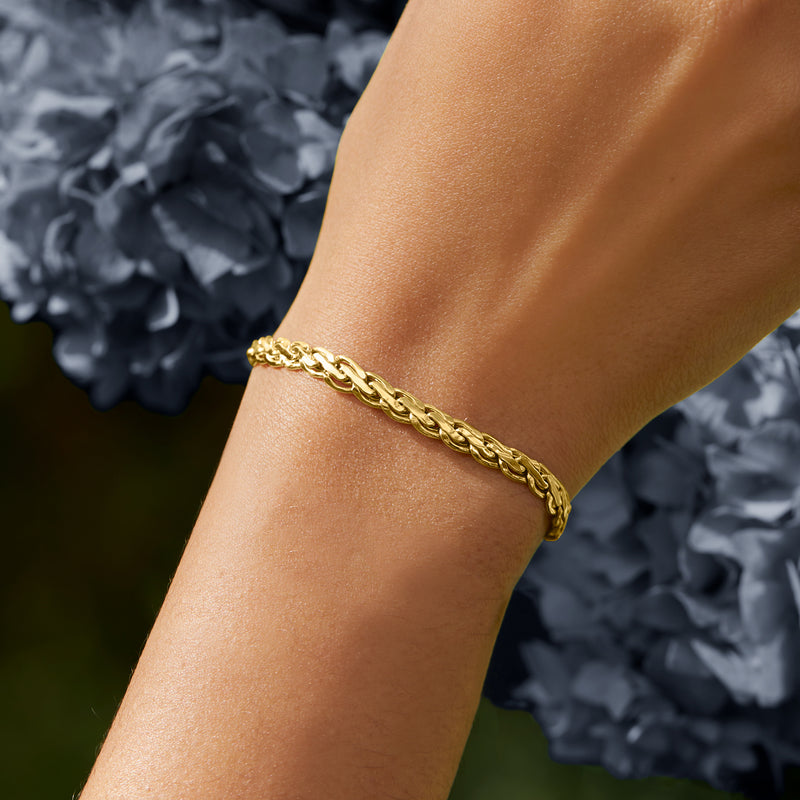 Yellow gold flat rope-chain bracelet close-up on wrist with bright link shine