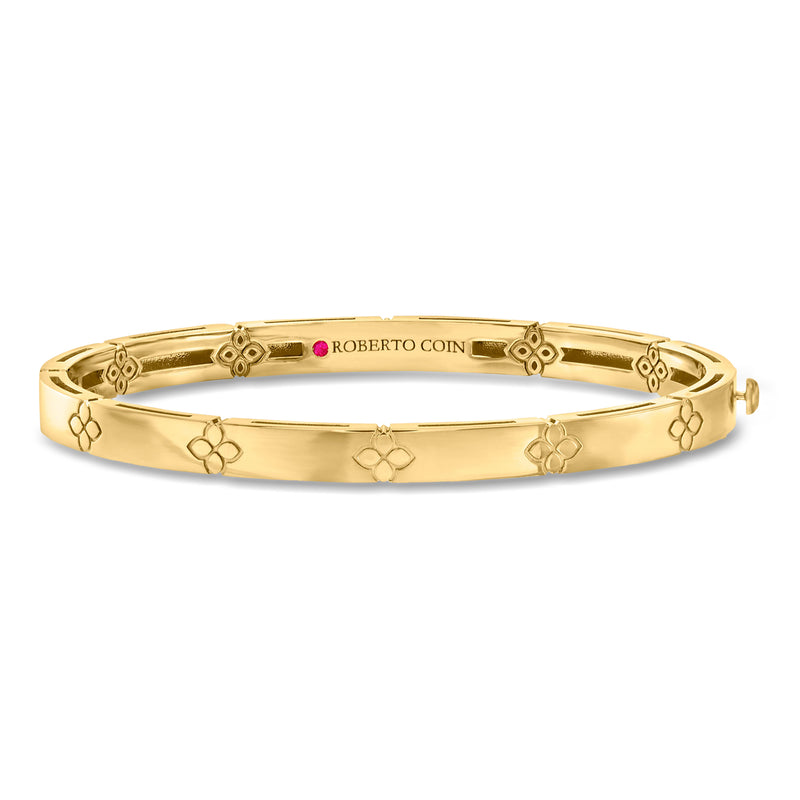18kt yellow gold bangle bracelet with floral motifs and small pink stone detail