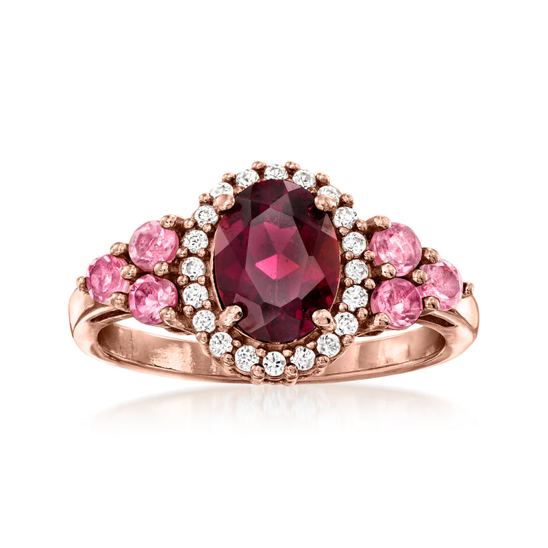 Rose gold ring with oval garnet center, pink side stones, and white zircon halo.