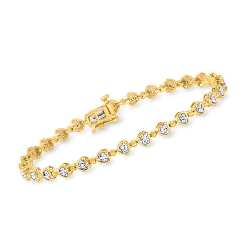 Gold tennis bracelet with heart-shaped diamond accents and round clear stones in prongs