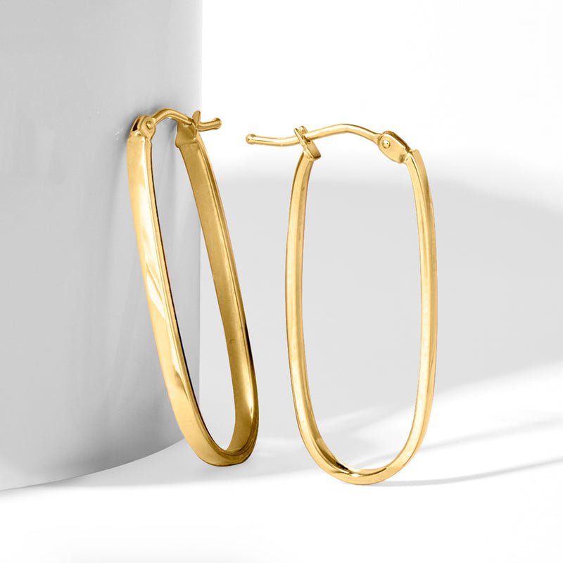 Yellow gold flat-oval hoop earrings, angled view showing inner curve