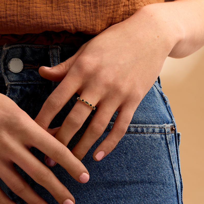 14kt yellow gold eternity band with blue gemstones on hand
