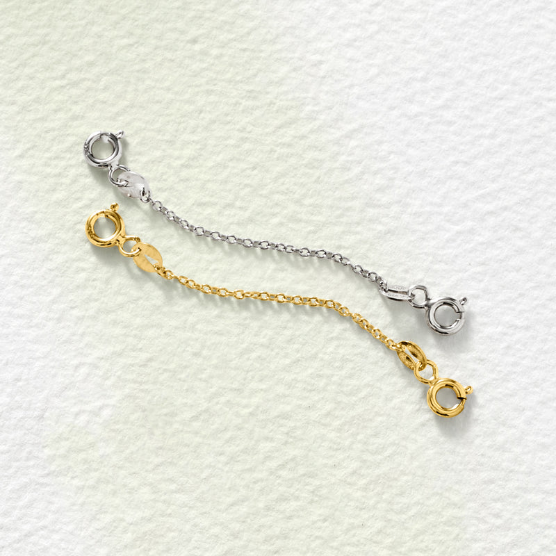 Two safety chains, silver and gold, with circular loop clasps laid flat