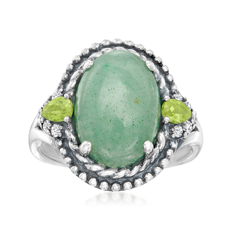 Sterling silver ring with oval green gemstone, green side stones, and halo of small accents