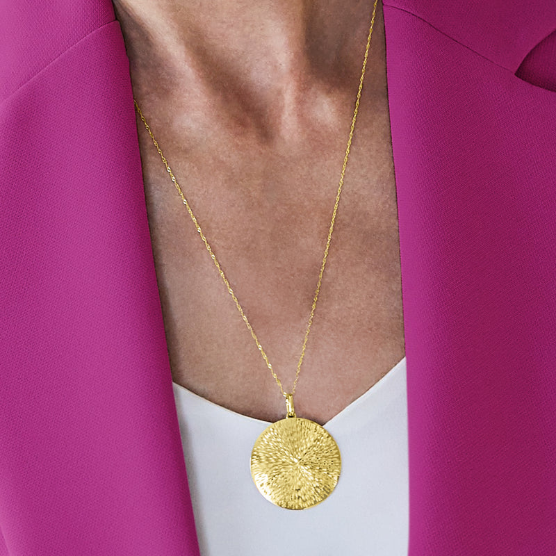 14kt yellow gold sunburst medallion pendant on chain at neckline
