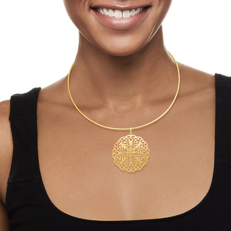 Yellow gold filigree medallion pendant on a model’s neckline