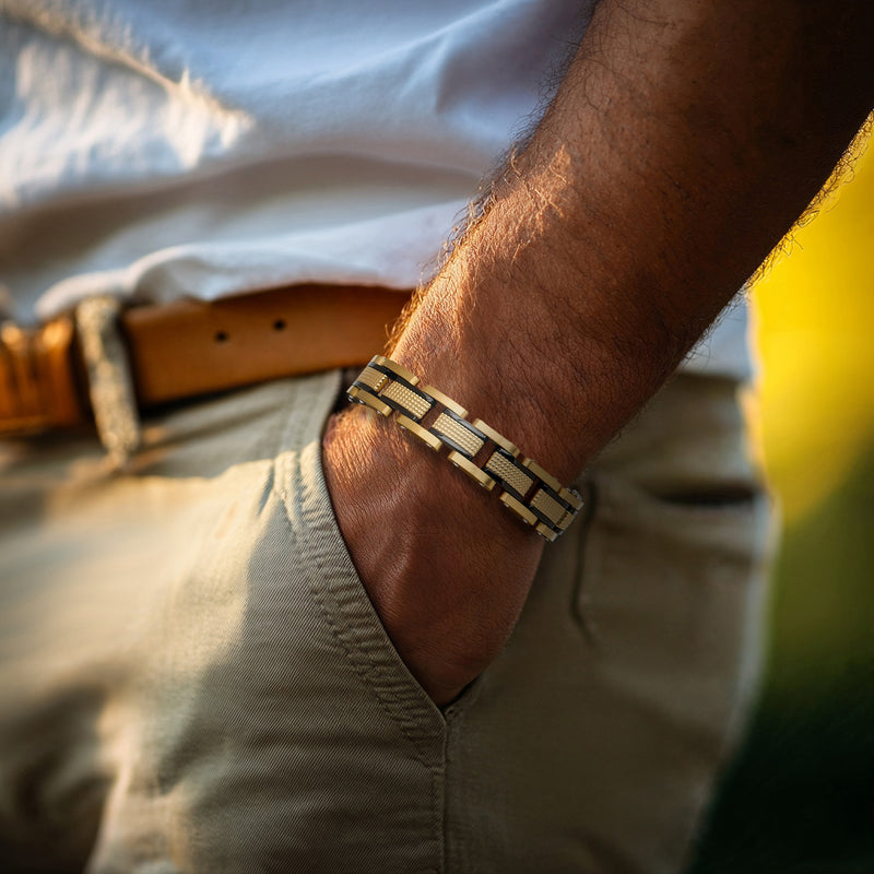 Gold-plated stainless link bracelet worn on wrist, alternating dark and gold segments