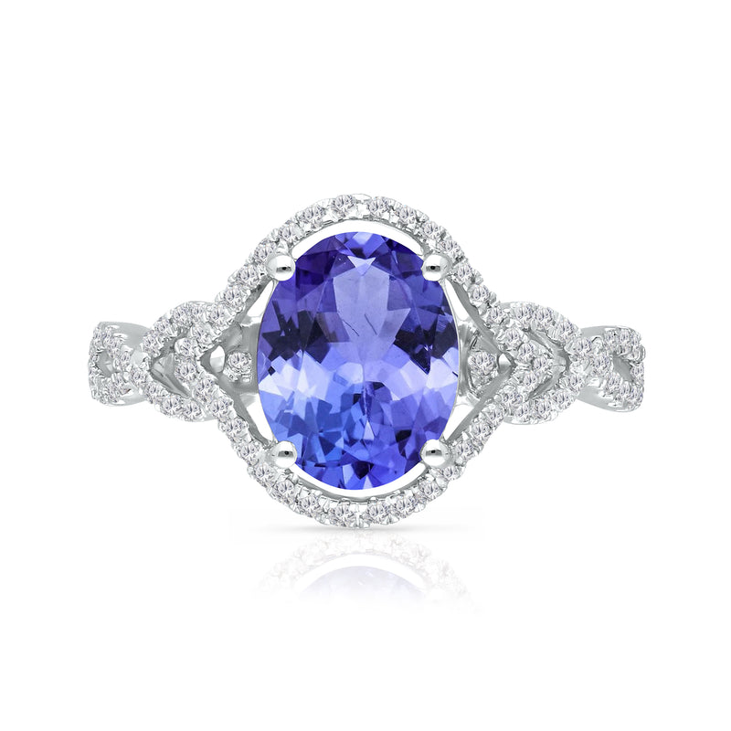 Oval tanzanite gemstone ring in 14kt white gold with diamond halo and side clusters