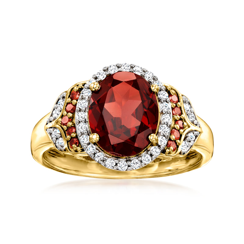 Gold-tone oval garnet ring with halo of white diamond accents and red side stones