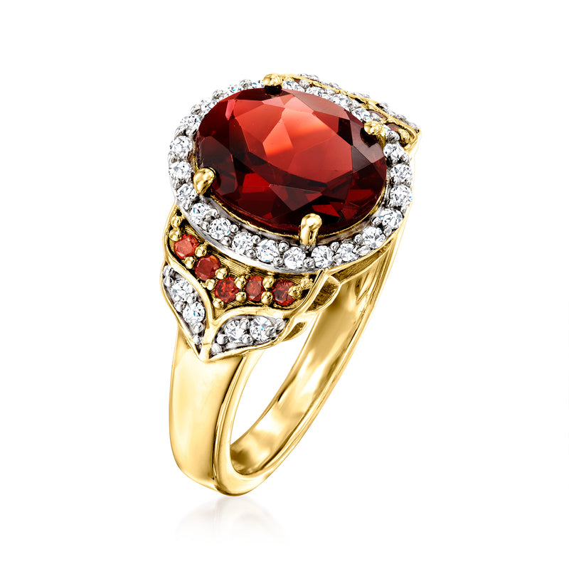 Gold-tone garnet ring, oval red center with white diamond halo and red side rows