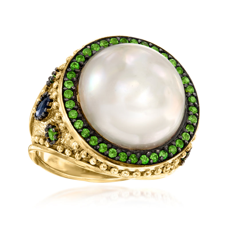 Gold mabe pearl ring with green halo and blue side cluster on textured band
