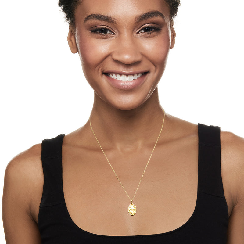 14kt yellow gold fleur-de-lis pendant necklace on thin chain, worn