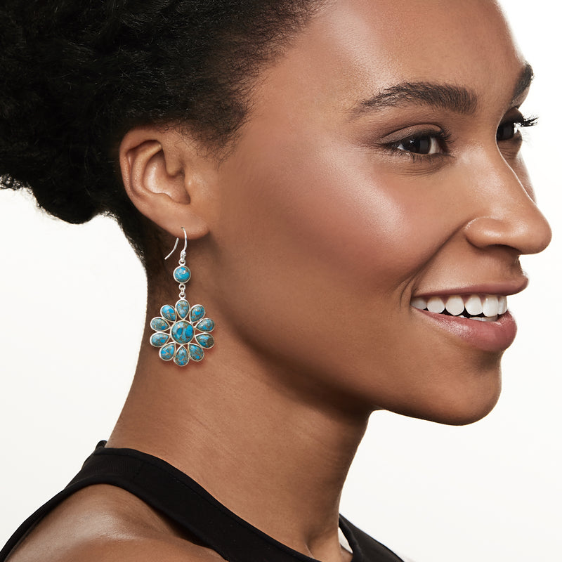 Turquoise flower drop earrings on ear with dangling sterling silver petal stones